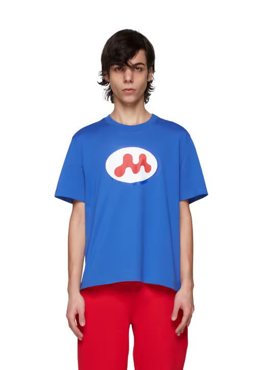 A man wearing a Mowalola blue t-shirt