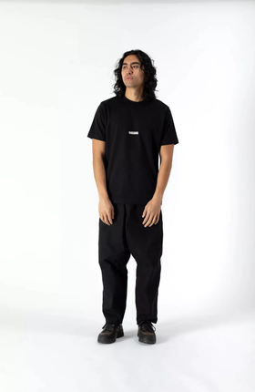A man wearing a WAWWA basic logo heavyweight organic black t-shirt