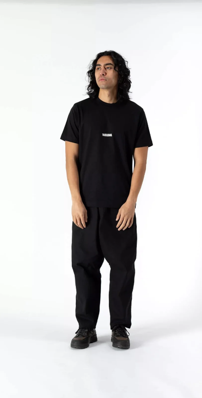 A man wearing a WAWWA basic logo heavyweight organic black t-shirt