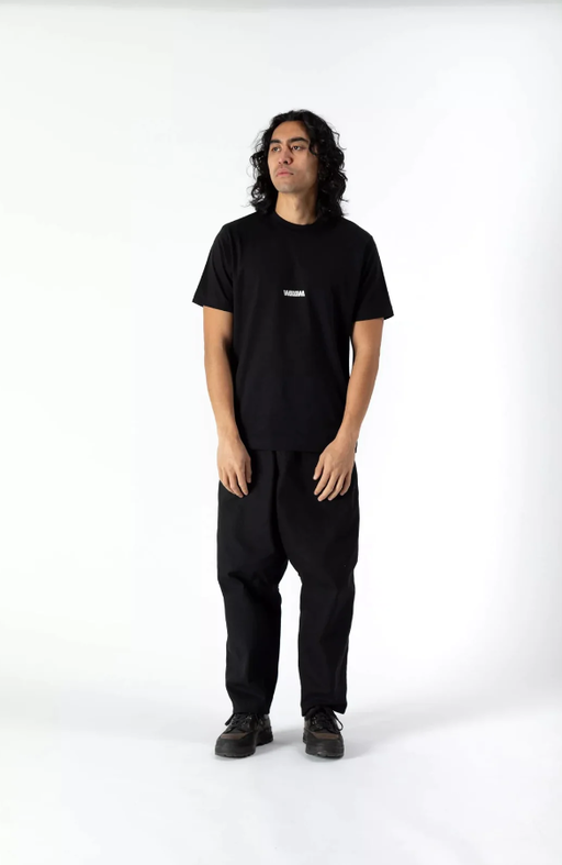A man wearing a WAWWA basic logo heavyweight organic black t-shirt