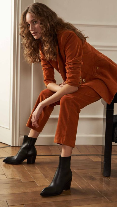 A woman wearing a pair of Gianvito Rossi black boot