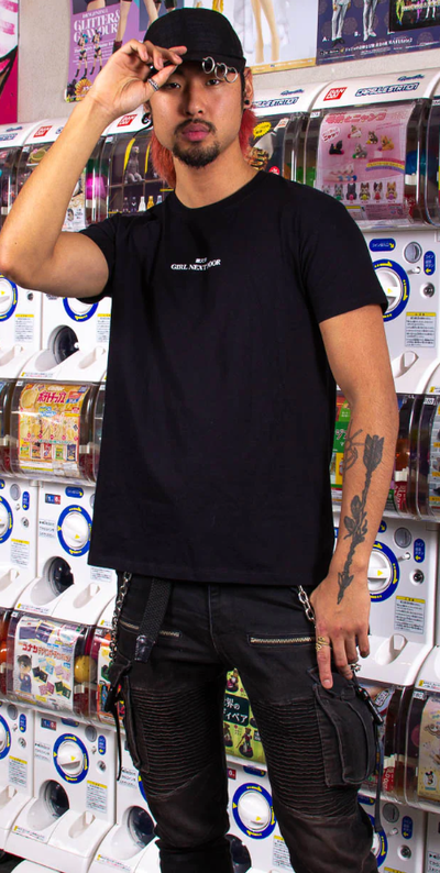 A man wearing a Kaomoji black t-shirt