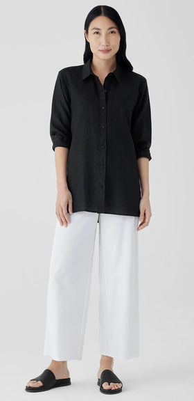 A woman wearing a Eileen Fisher black organic handkerchief linen classic collar shirt