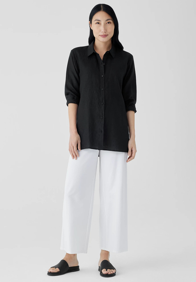 A woman wearing a Eileen Fisher black organic handkerchief linen classic collar shirt