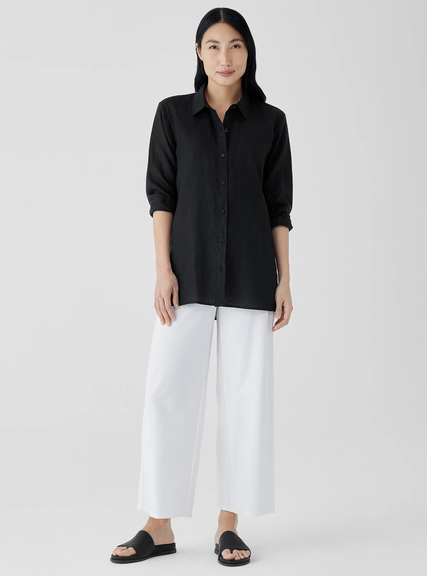 A woman wearing a Eileen Fisher black organic handkerchief linen classic collar shirt
