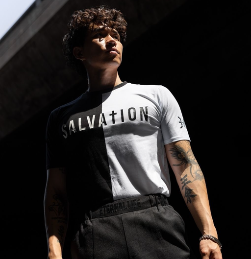 A man wearing a  3:16 Collection black and white t-shirt