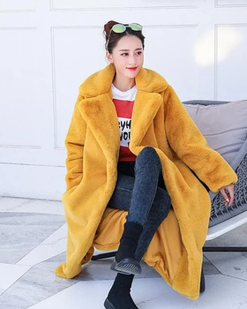 A woman wearing a Spreepicky yellow winter faux fur long fluffy jacket coat
