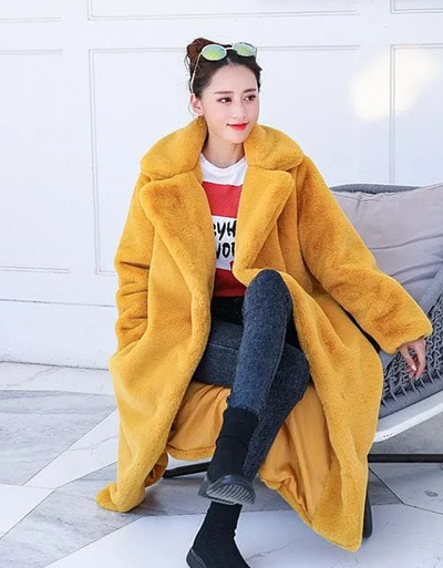 A woman wearing a Spreepicky yellow winter faux fur long fluffy jacket coat