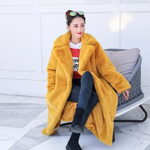 A woman wearing a Spreepicky yellow winter faux fur long fluffy jacket coat
