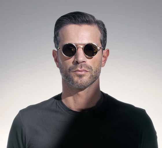A man wearing a Akoni Eyewear brushed white gold designer sunglasses