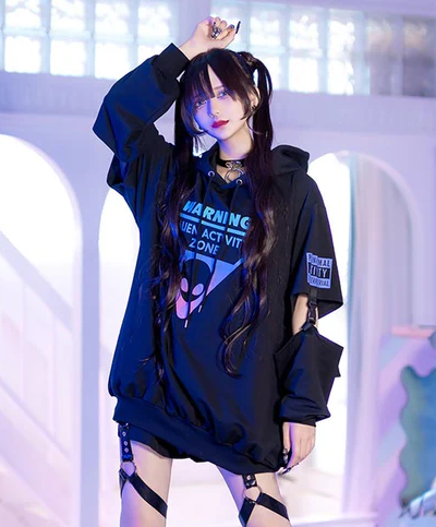 A woman wearing a Harajuku Hearts alien separate sleeve belt black hoodie