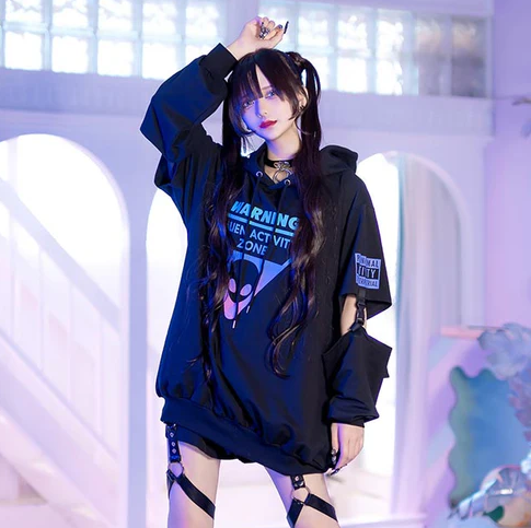A woman wearing a Harajuku Hearts alien separate sleeve belt black hoodie