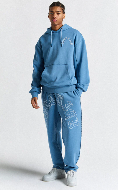 A man wearing a Hoodrich blue Hoodie and Joggers