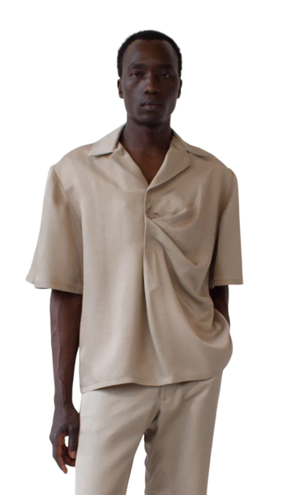 A man wearing a Bianca Saunders soft beige bailey shirt