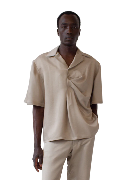 A man wearing a Bianca Saunders soft beige bailey shirt