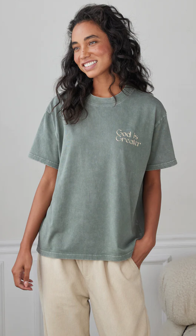 A woman wearing a Elevated Faith moss t-shirt