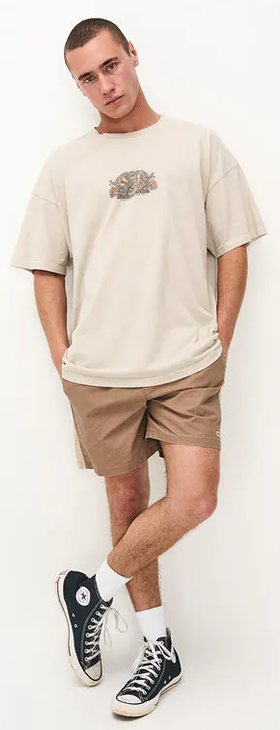 A man wearing a Ghanda Clothing surf wax white maui t-shirt