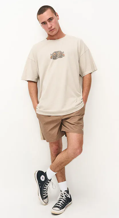 A man wearing a Ghanda Clothing surf wax white maui t-shirt