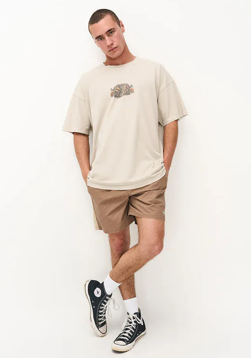 A man wearing a Ghanda Clothing surf wax white maui t-shirt