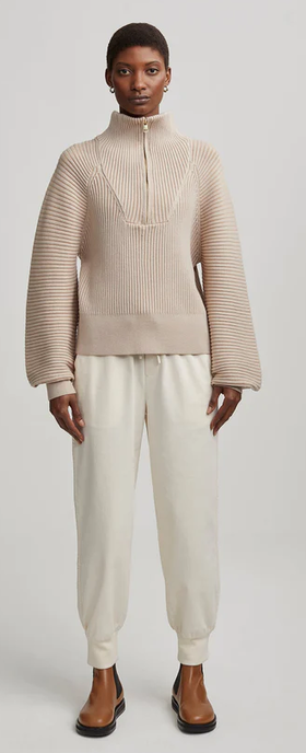 A woman wearing reid half-zip knit sweater