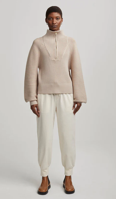 A woman wearing reid half-zip knit sweater