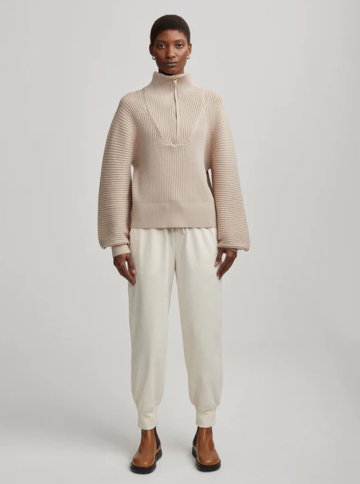A woman wearing reid half-zip knit sweater