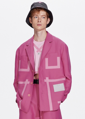 A man wearing a pink tape patchwork blazer