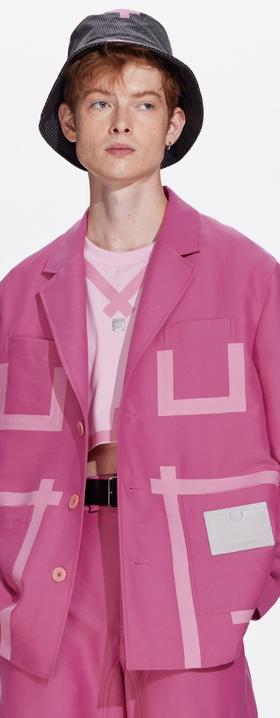 A man wearing a pink tape patchwork blazer