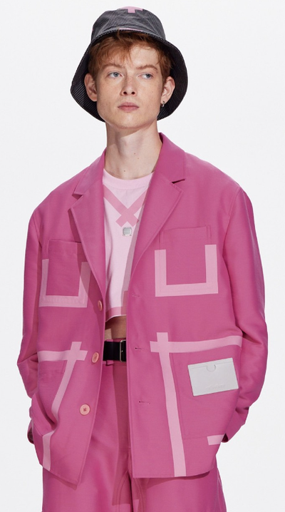 A man wearing a pink tape patchwork blazer