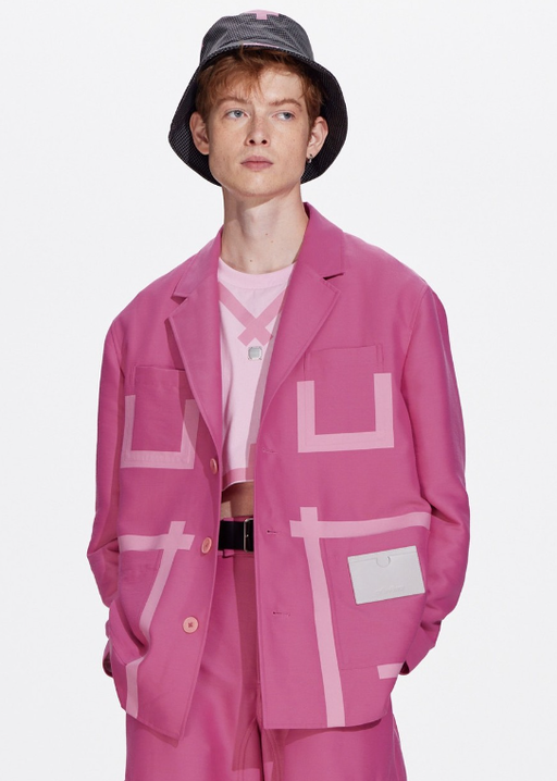 A man wearing a pink tape patchwork blazer