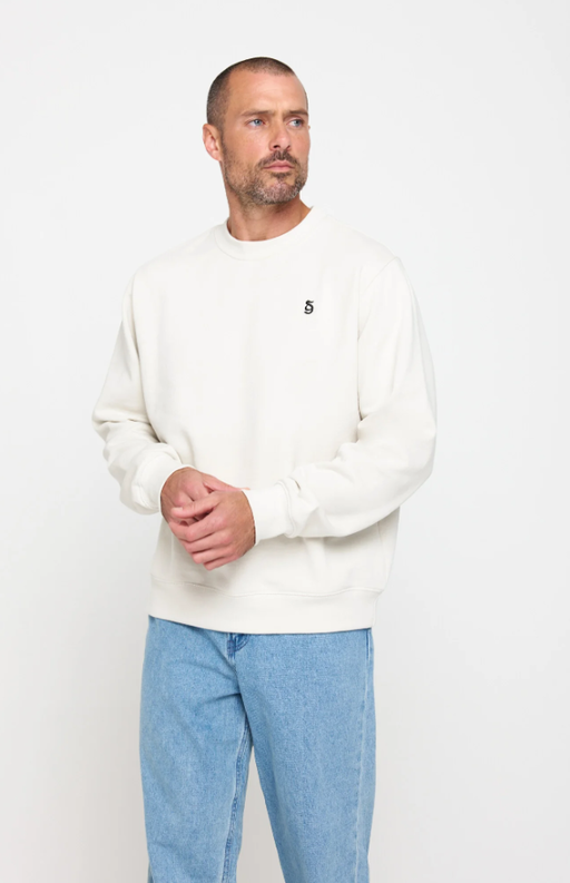A man wearing birch color sg monogram classic crew pullover