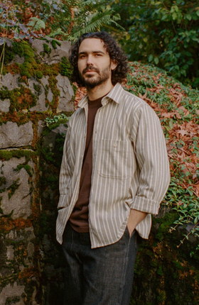 A man wearing pedal-loom woven taupe striped pintor shirt