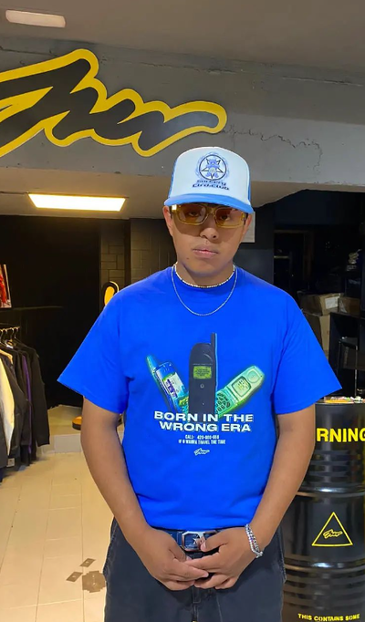 A man wearing blue color born in the wrong era printed t-shirt