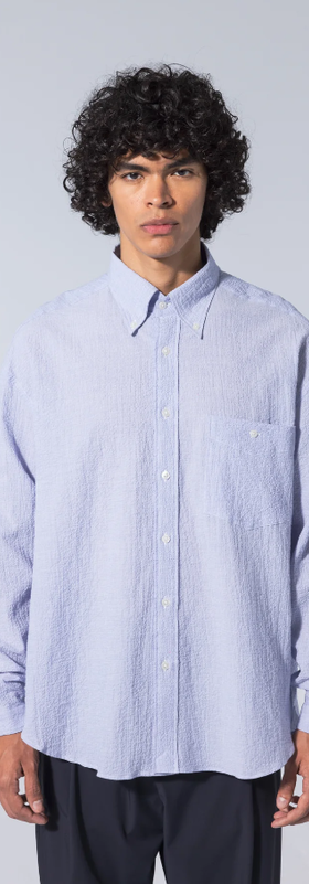 A man wearing long sleeve baggy shirt seersucker