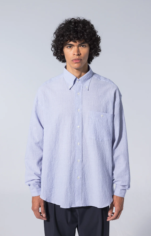 A man wearing long sleeve baggy shirt seersucker