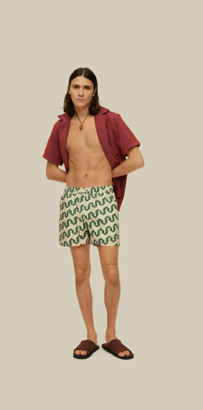 A man wearing a OAS atlas swim shorts