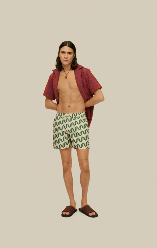 A man wearing a OAS atlas swim shorts