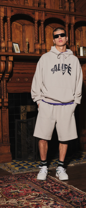 A man wearing ivory grey trap logo hoodie