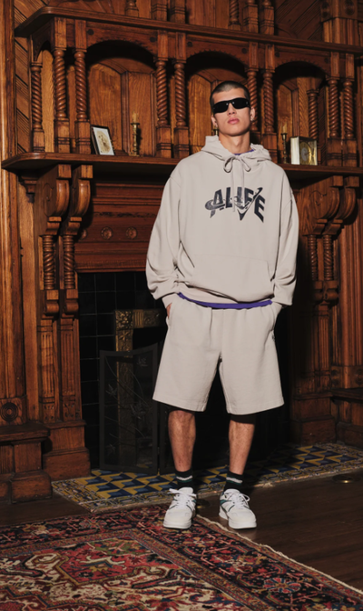 A man wearing ivory grey trap logo hoodie
