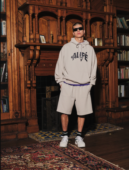 A man wearing ivory grey trap logo hoodie