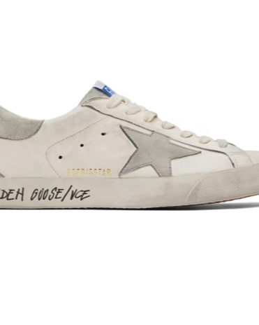 A close up of a pair of a Golden Goose star shoe in white with cursive writing on it