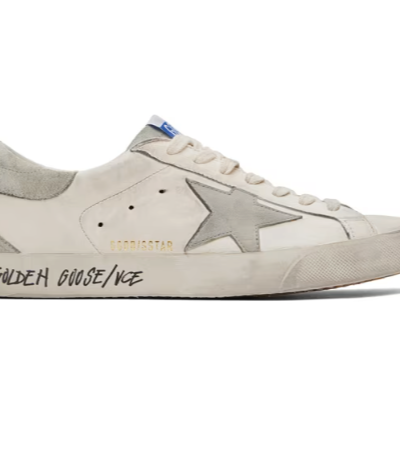 A close up of a pair of a Golden Goose star shoe in white with cursive writing on it