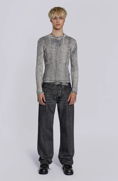A man wearing a Jaded London black shirt with oversize dark grey jeans