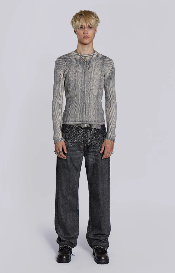 A man wearing a Jaded London black shirt with oversize dark grey jeans