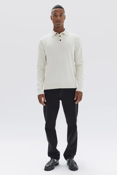 A man wearing a long sleeve white Assembly Label shirt and black pants