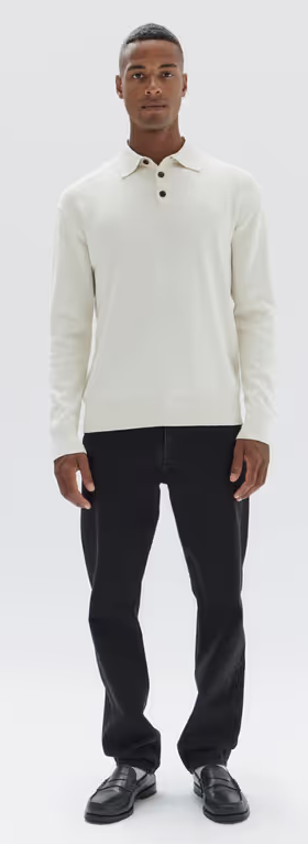 A man wearing a long sleeve white Assembly Label shirt and black pants