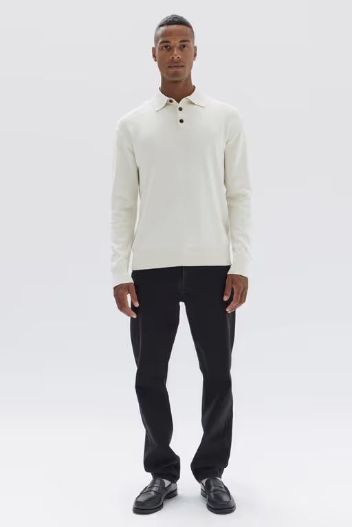 A man wearing a long sleeve white Assembly Label shirt and black pants