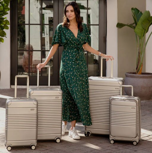 A woman with multiple Arlo Skye suitcases in beige