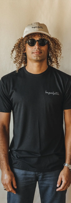 A man wearing a Imperfects Overalls tee w/ brushstroke in black