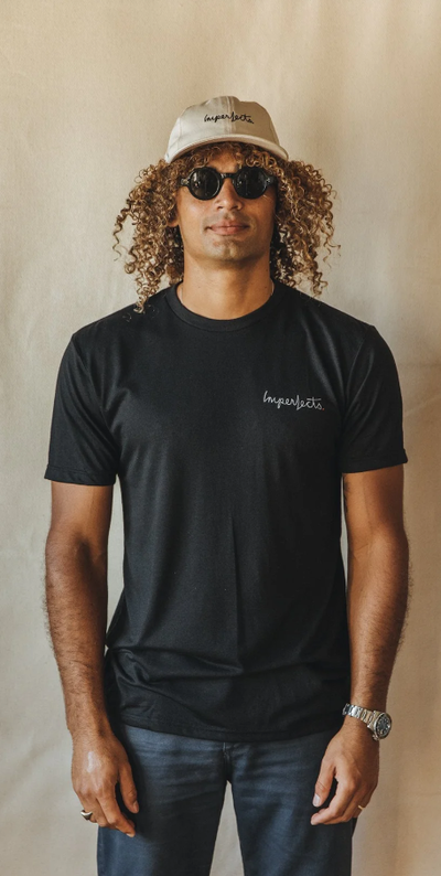 A man wearing a Imperfects Overalls tee w/ brushstroke in black